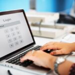 hands with accessories typing on the keyboard laptop with word login on it